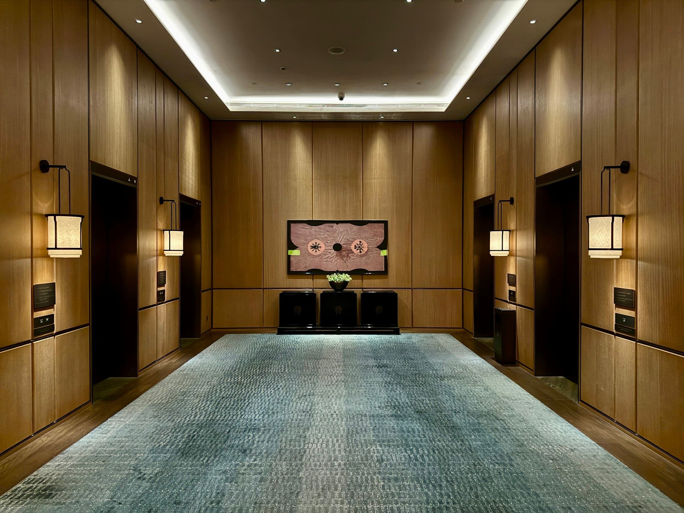 Hotel lift lobby finished in warm timber panelling